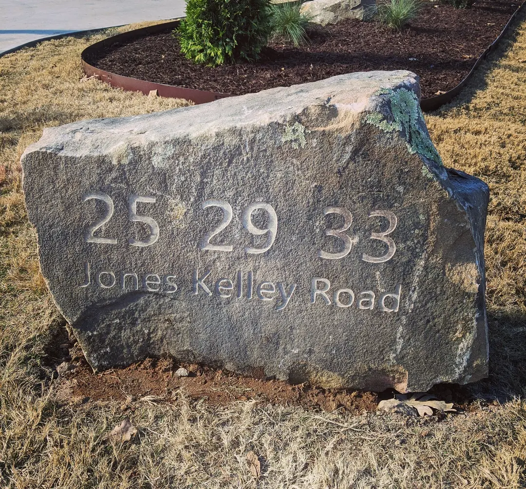Jones Kelley Road address engraved into a natural boulder