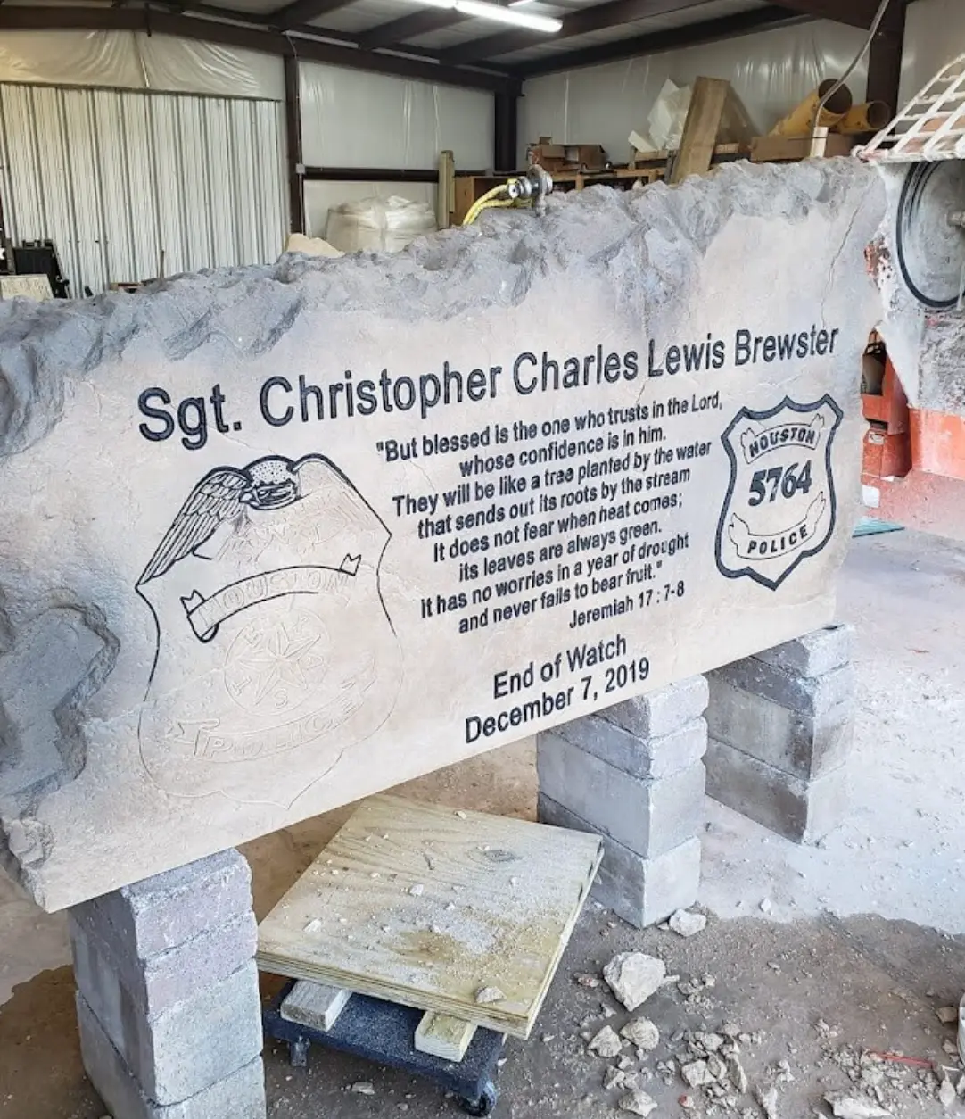 Police officer memorial stone with engraved badges and scripture