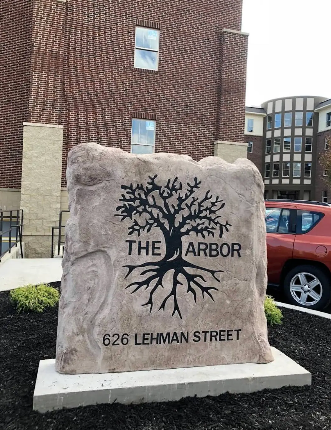 The Arbor monument stone with an engraved tree and address
